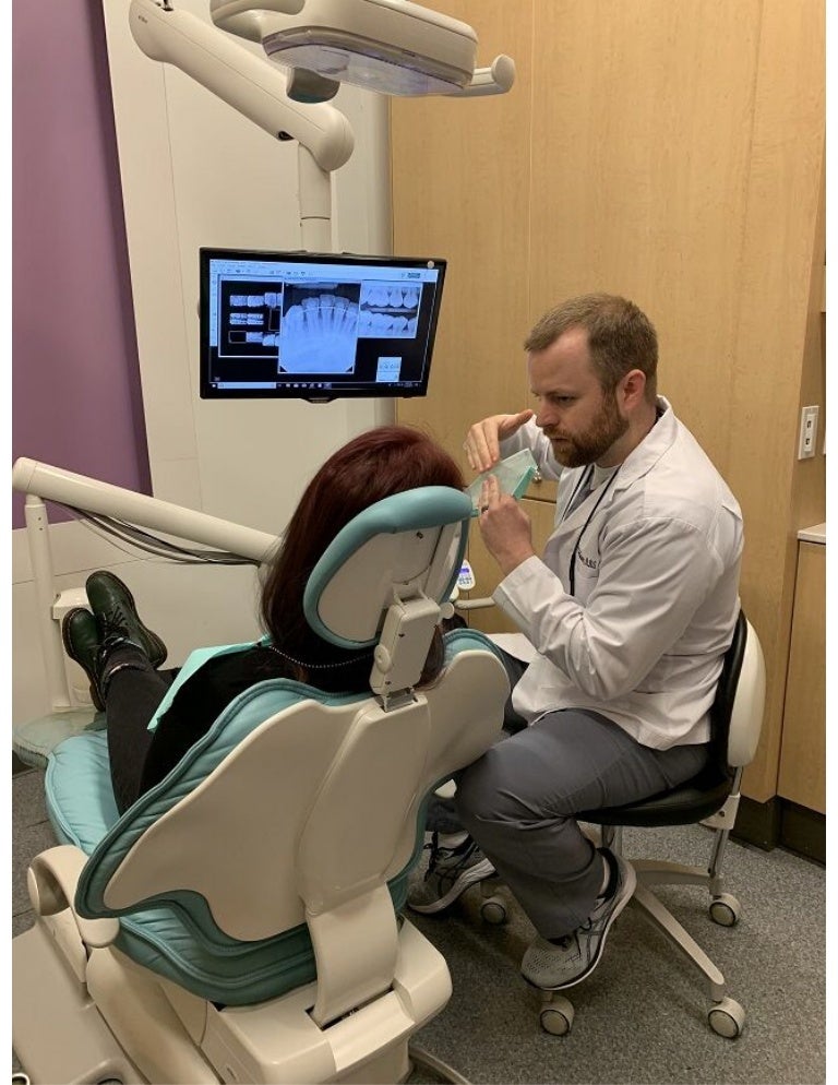 Fayetteville AR dentist Dr. McQueen talking to patient at McQueen Den…